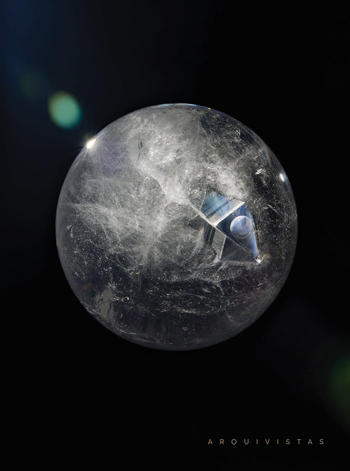 Arquivistas book cover image with foil letters. Enhydro Quartz Sphere suspended against a black background. Published by Art & Anthropology Press. 